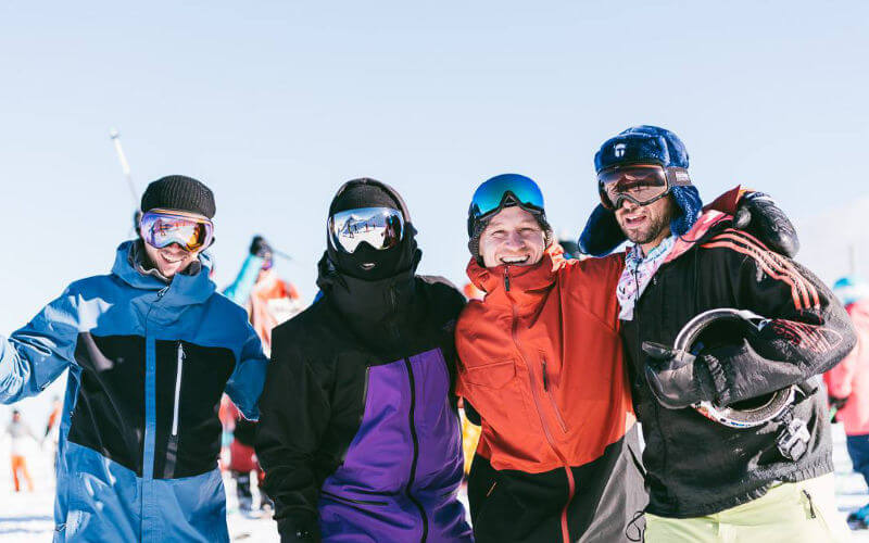 Group of skiers and snowboarders enjoying a sunny day in the mountains
